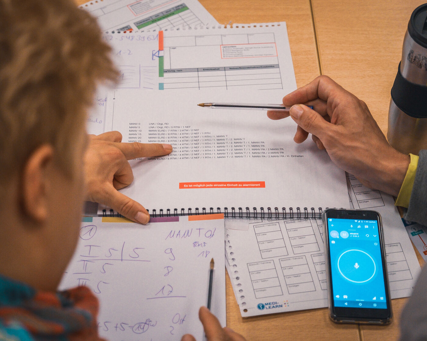 Ein Teilnehmer notiert die Lage auf einem Sichtungsbogen, daneben ein Smartphone mit Stoppuhr