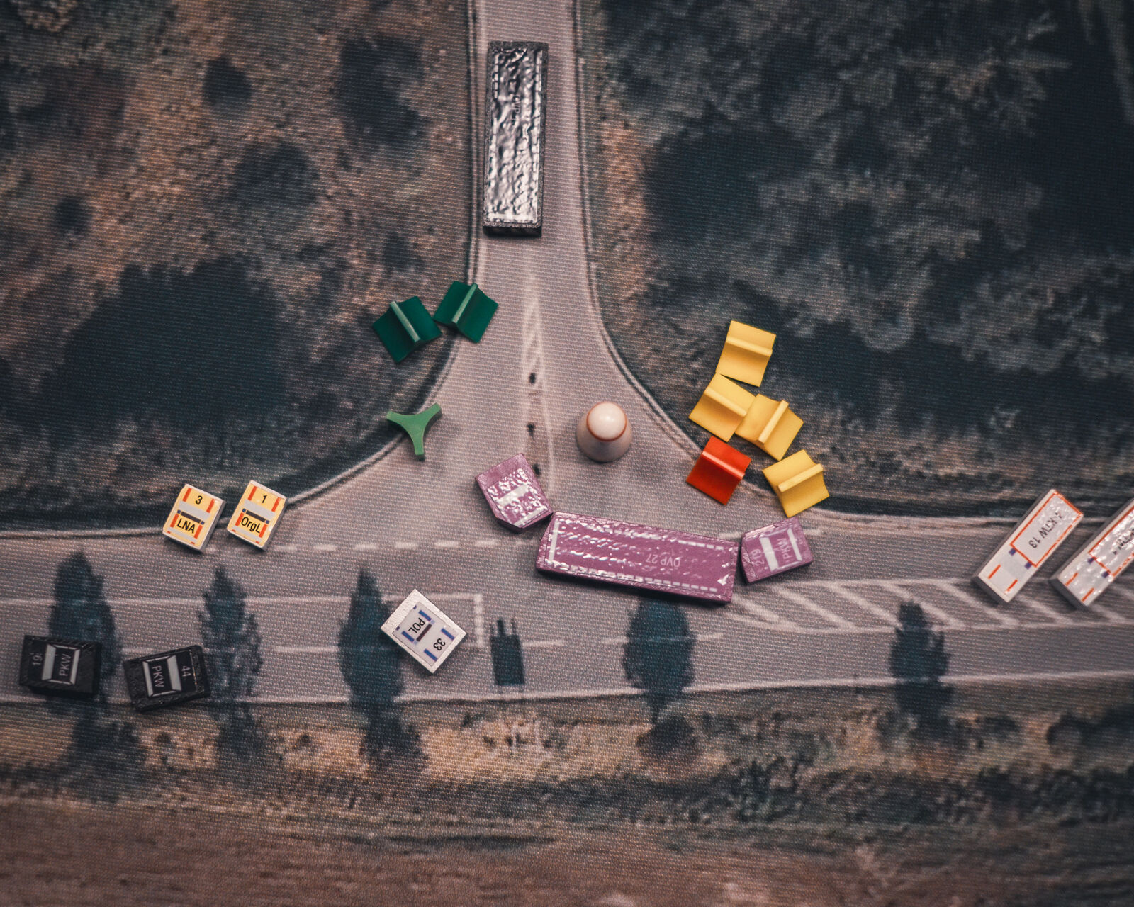 Fahrzeugmodelle und Figuren an einer Straßenkreuzung auf dem Luftbild des MANV-Simulationssystems