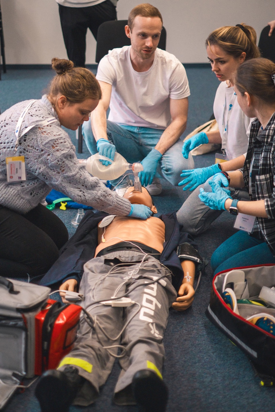 Eine Gruppe von Teilnehmenden übt die Atemwegssicherung an einer Simulationspuppe